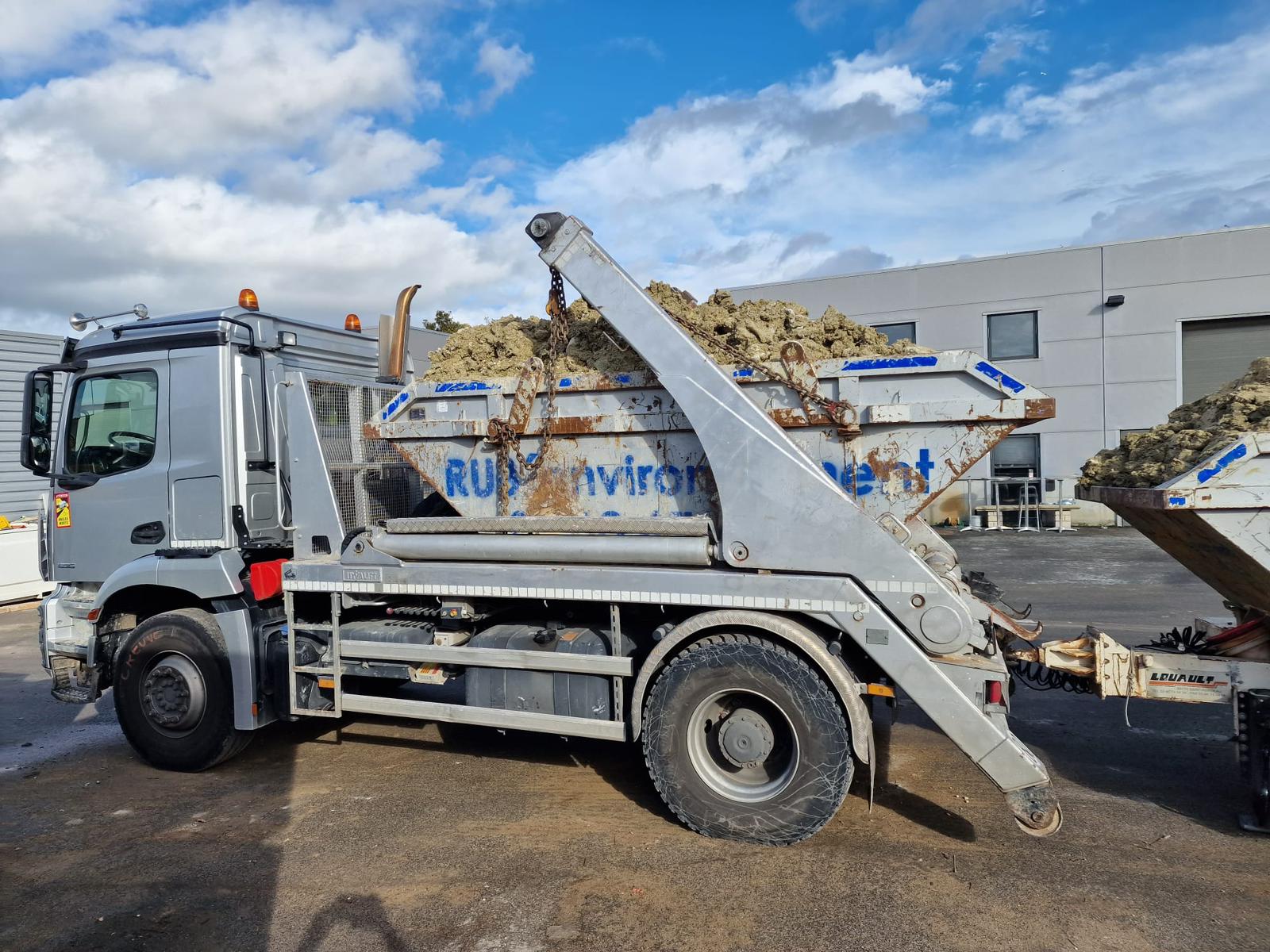 camion qui transporte des bennes pleine de terre.